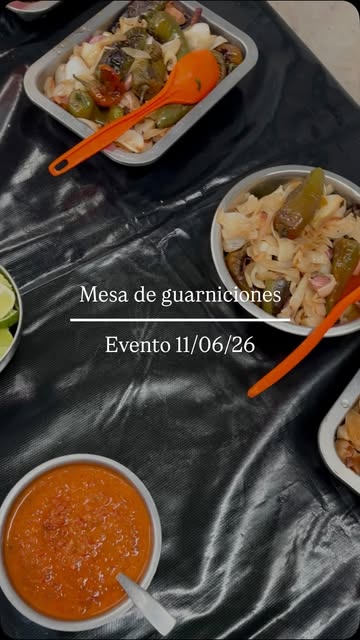 Mesa de guarniciones montada en un evento, con salsas y limones