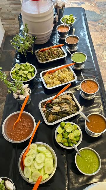 Mesa completa de guarniciones con salsas, limones, nopales y frijoles