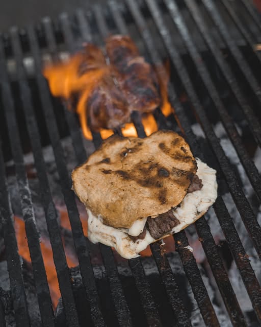 Queso fundido con arrachera sobre tortilla en la parrilla