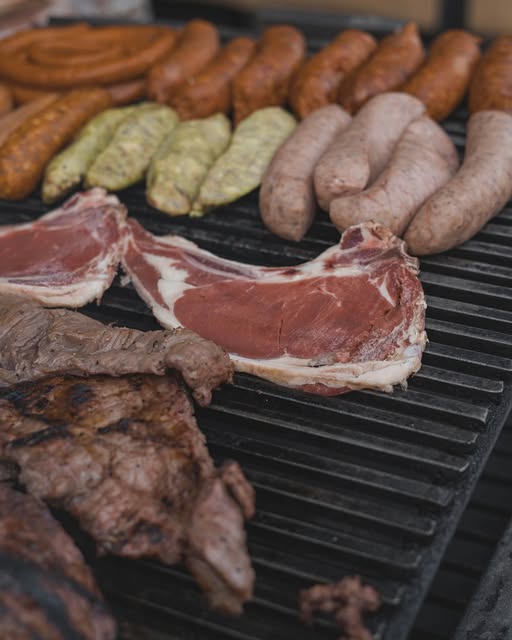 Chuletas, chorizos, chistorras y nopales acomodados en la parrilla